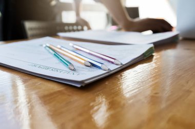 Kalemler ve rapor kağıtları ofisteki ahşap masa üzerine işadamı geçmişine sahip.