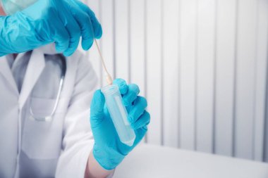 Doktor ya da tıbbi personel laboratuvarda muayene için hastadan salgılar topluyor. Salgın Koronavirüs, COVID-19.