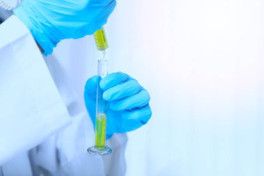 Araştırmacı ya da bilim adamları laboratuardaki test tüpüne sıvı örneği yüklüyorlar. Araştırmacılar COVID-19 virüsünü tedavi etmek için aşı ve ilaç geliştiriyorlar..