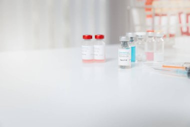 Bir tıp laboratuarında çalışma masasında Coronavirus aşısı (COVID-19) örneği.