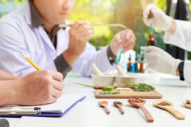 Taze bitkilerle bitkisel ilaç hazırlama ve doğal alternatif ilaçlarda kullanılan kurumuş çiçekler. Bilim adamı ya da doktor laboratuvarda bitkisel ilaç yapıyor..