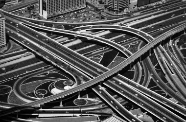 Yukarıdan görünen kavşak yolları. Şehir merkezindeki Dubai otoyolunda trafik vardı. Yüksek kontrastlı soyut siyah beyaz fotoğraf.