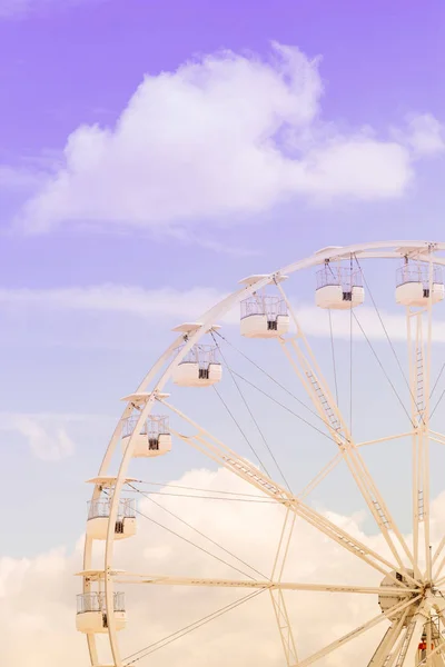 Riesenrad auf dem bunten wolkenverhangenen Himmel.Hintergrundkonzept der frohen Urlaubszeit. Stockbild