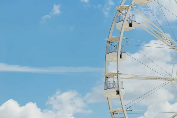 Ferris wheel on the blue cloudy sky. Background concept of happy holidays time. Royalty Free Stock Images