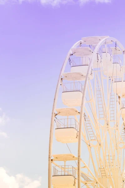 Riesenrad am bunten bewölkten Himmel. Hintergrundkonzept der glücklichen Urlaubszeit. Stockfoto