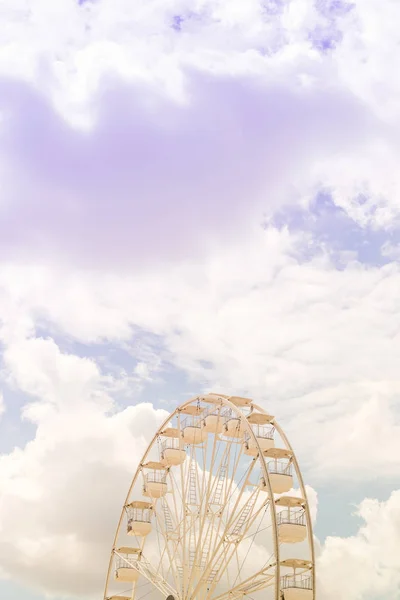 Riesenrad am bunten bewölkten Himmel. Hintergrundkonzept der glücklichen Urlaubszeit. Stockbild