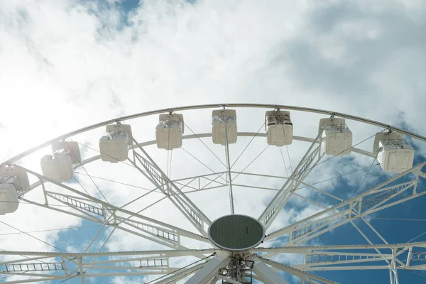 Ferris wheel on the blue cloudy sky. Background concept of happy holidays time. Stock Photo