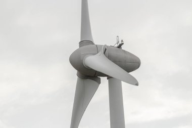 Rüzgar türbini bulutlu bir günde dönüyor. Elektrik enerjisi üretimi modern teknoloji. Yenilenebilir enerji kaynakları kavramı. Ekoloji ve çevre dostu enerji üretimi. Yakın çekim