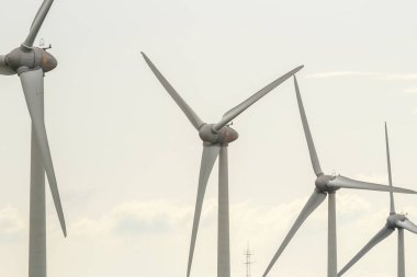 Rüzgar türbini bulutlu bir günde dönüyor. Elektrik enerjisi üretimi modern teknoloji. Yenilenebilir enerji kaynakları kavramı. Ekoloji ve çevre dostu enerji üretimi. Yakın çekim