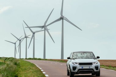 Normandiya, Fransa'da ülke yoluna yakın elektrik üretimi için bir elektrik santralinin rüzgar türbinleri. Kırsal arazi. Çevre dostu elektrik üretimi