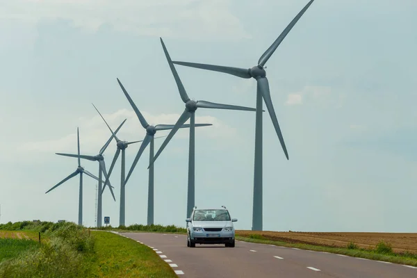 Normandiya, Fransa'da ülke yoluna yakın elektrik üretimi için bir elektrik santralinin rüzgar türbinleri. Kırsal arazi. Çevre dostu elektrik üretimi