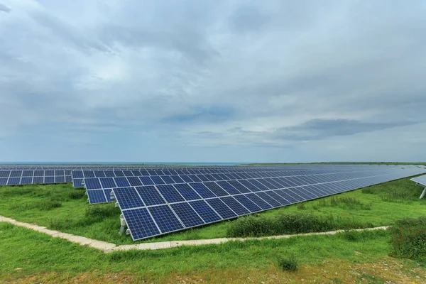 Solpaneler på en molnig dag i Normandie, Frankrike. Solenergi, modern elkraft produktionsteknik, förnybar energikoncept. Miljövänlig elproduktion — Stockfoto