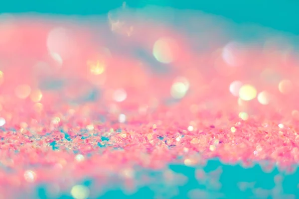 Pink sparkles on a blue background. Defocused. Abstract background for your design.