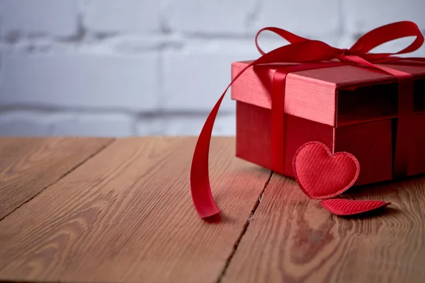 Подарунка або подарунок коробку з червоний лук стрічки і блиск серце на тлі сільському день Святого Валентина. — стокове фото