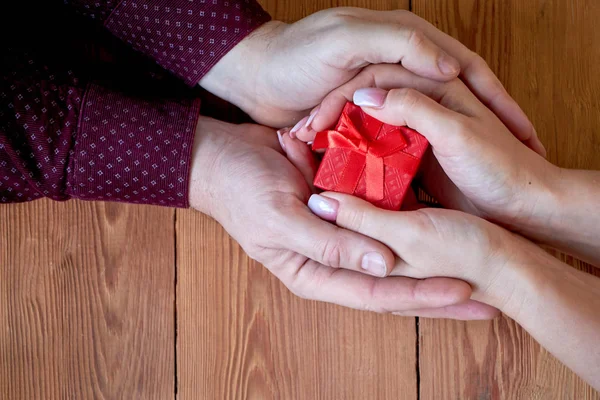Kobieta z człowieka posiadającego dar w ręku na tle drewnianych na Walentynki lub na Boże Narodzenie. — Zdjęcie stockowe