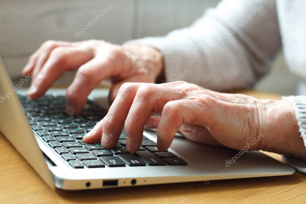 Senior elderly business woman working on laptop.
