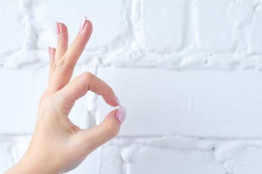 Beyaz tuğla duvar arka plan üzerinde izole el hareketi.
