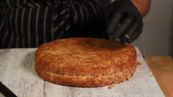 Nemen van kant en klare spons cakes uit de oven, snijden ze in cakes voor het maken van een moer-banaan cake, een volledig proces voor het maken van een taart, beeldmateriaal — Stockvideo