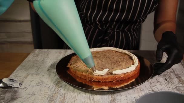 Montaje de las capas de pastel de nuez y plátano, untando con jarabe, aplicando crema de mantequilla, llenando el relleno, todo el proceso de hacer el pastel, material de archivo — Vídeo de stock