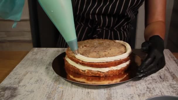 Сборка орехово-банановых слоев торта, размазывание сиропом, нанесение сливочного крема, наполнение начинки, весь процесс приготовления торта, кадры из запаса — стоковое видео