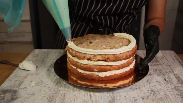 Montaje de las capas de pastel de nuez y plátano, untando con jarabe, aplicando crema de mantequilla, llenando el relleno, todo el proceso de hacer el pastel, material de archivo — Vídeos de Stock