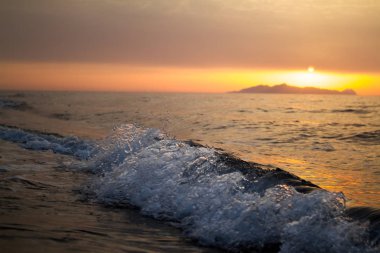 Deniz yüzeyinin altında büyük sarı güneşli parlak gün batımı