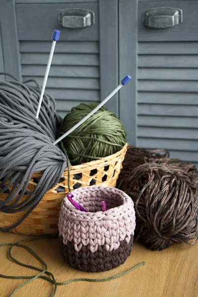 Traditional colorful yarns for hobby knitting in a straw eco basket on a light wooden surface. — Stock Photo, Image