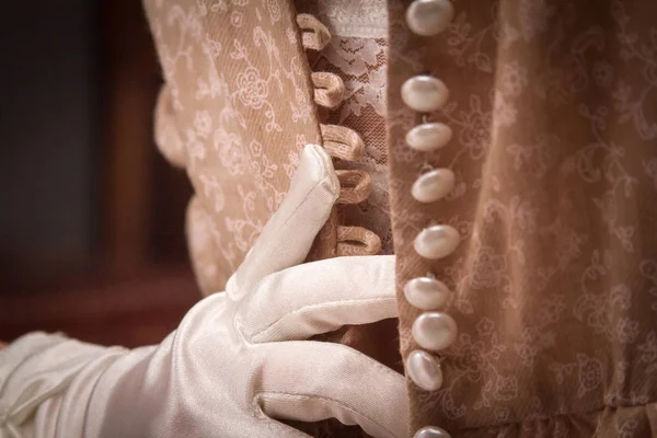 Eine junge Frau in Vintage-Dessous und weißen Handschuhen zieht das Kleid ihrer Freundin aus, viele Knöpfe. ein kleines Korn hinzugefügt, Nachahmung der Filmfotografie — Stockfoto