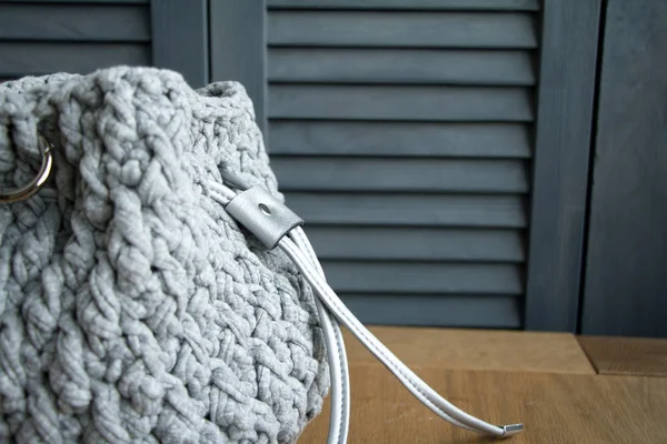 Extreme close-up of a handmade knitted bag in detail. Gray bag with leather bottom and straps. — Stock Photo, Image