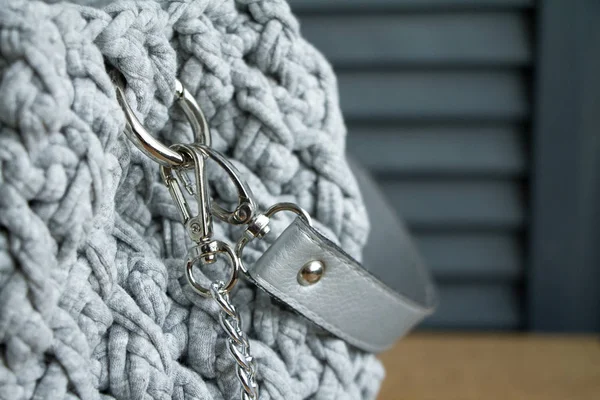 Extreme close-up of a handmade knitted bag in detail. Gray bag with leather bottom and straps. — Stock Photo, Image