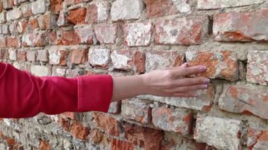 4k kadın eli eski tuğla duvara hareket ediyor. Birlikte kayar. Şehvetli dokunuşa. Sert taş yüzey. Duyusal deneyim