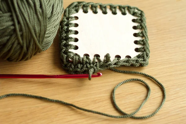 Holzteile, Häkelhaken und grünes Garn für handgestrickte Taschen. Selektiver weicher Fokus. — Stockfoto