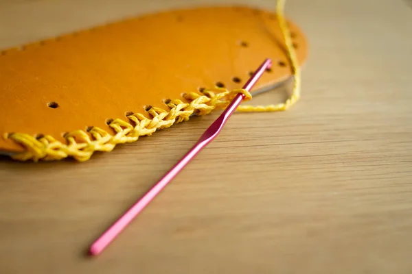 Skinn detaljer, virknål och gult garn för att tillverka handgjorda stickade väskor. Selektivt mjukt fokus. — Stockfoto