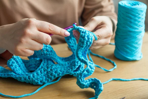 Extremt nära stickning från beige garn, nål, virka krokar. Arbeta med en ny produkt. Selektivt mjukt fokus. — Stockfoto