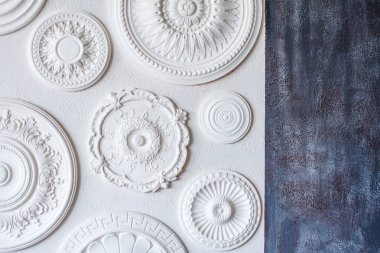 A two-color background, gray decorative plaster and a white wall with several white ceiling rosettes clipart