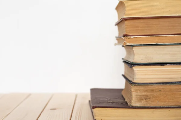 Egy köteg évjárat könyvek üzleti és oktatási egy fából készült felület ellen, a fehér fal. — Stock Fotó