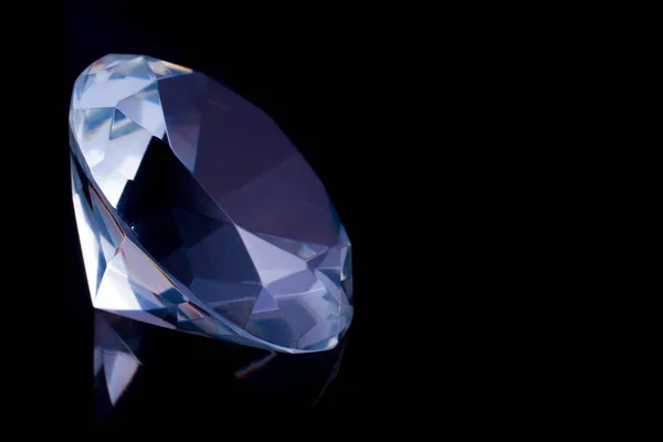 Ein riesiger Diamant auf einer schwarzen Spiegeloberfläche, ein Spiegelbild eines Diamanten. — Stockfoto