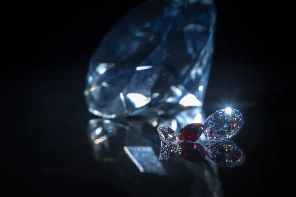 Riesiger Diamant und mehrere schicke Kristalle auf tiefschwarzer Spiegeloberfläche, schimmern und funkeln. — Stockfoto