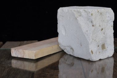 Ahşap bir tahta ve bir parça tuğla yalan cam.