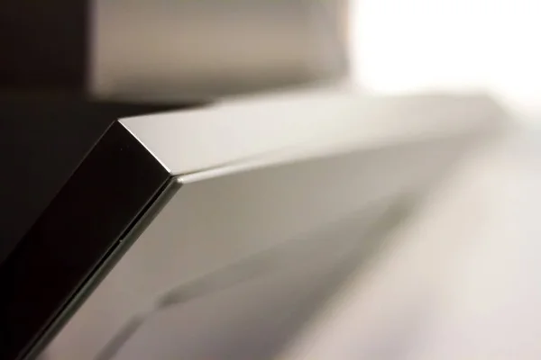 Extreme close-up stainless steel kitchen cupboard, on a white background.