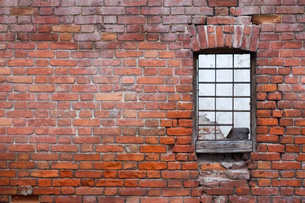 Venster met balken op de achtergrond van de bakstenen muur van het oude huis — Stockfoto