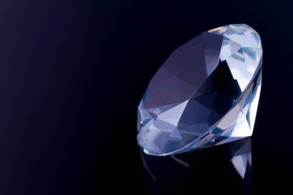 Ein riesiger Diamant auf einer schwarzen Spiegeloberfläche mit der Reflexion eines Diamanten — Stockfoto