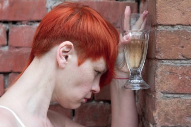 Genç çekici kadın depresyon ve stres sokakta şarap içme bardak acı.