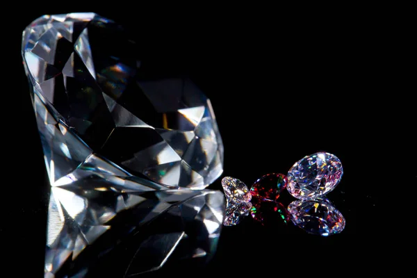 Τεράστιο διαμάντι και αρκετοί σικ κρύσταλλοι σε μια βαθιά μαύρη επιφάνεια καθρέφτη, λάμψη και λάμψη — Φωτογραφία Αρχείου