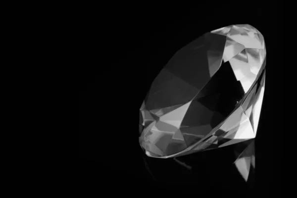 Ein riesiger Diamant auf einer schwarzen Spiegeloberfläche mit Reflexion eines Diamanten, Schwarz-Weiß-Foto — Stockfoto