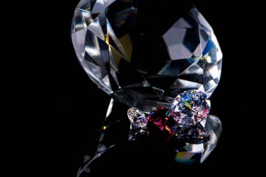 Derin siyah ayna yüzeyinde büyük elmas ve çeşitli şık kristaller, ışıltılı ve ışıltı