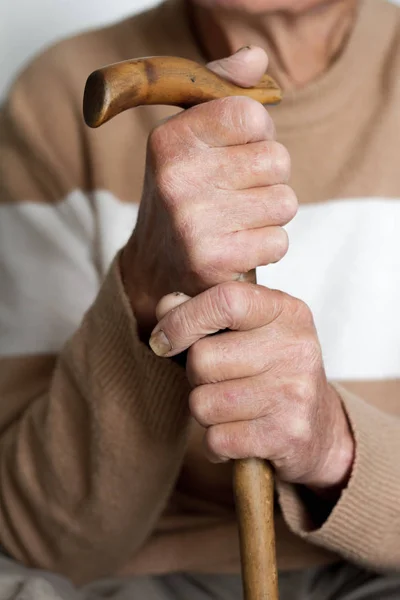 Primo piano delle mani di una persona molto anziana in un concetto di salute del maglione beige — Foto Stock