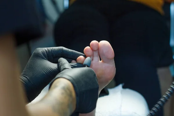 Medical pedicure. Podologist develops feet with a milling machine