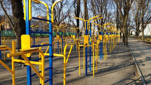 Amarelo-azul equipamento de exercício localizado na rua para esportes, fitness, conceito de treino de rua — Fotografia de Stock