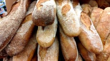 Motio mağaza raflarında altın renkli ekmek, çörekler ve diğer fırın ürünleri.